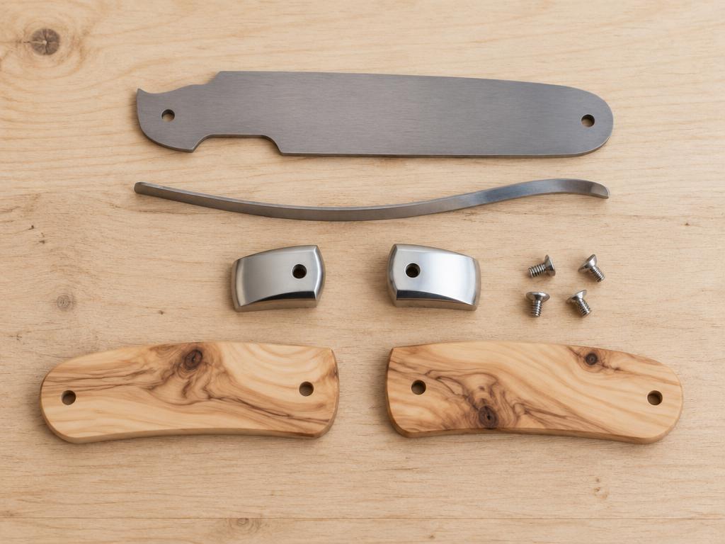 Visuel d'illustration : pièces détachées d'un couteau pliant (lame, ressort, mitres, plaquettes de bois) sur un établi